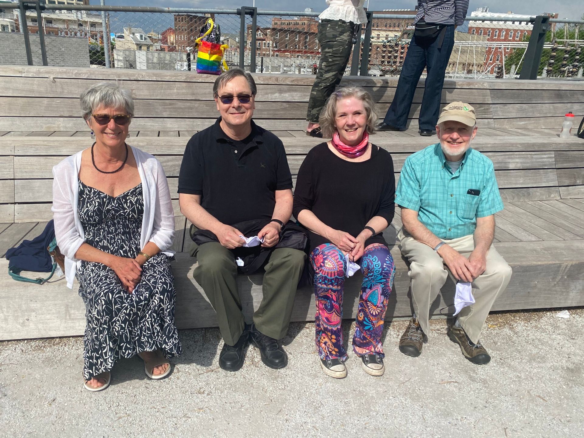 A group of people are sitting on a wooden bench