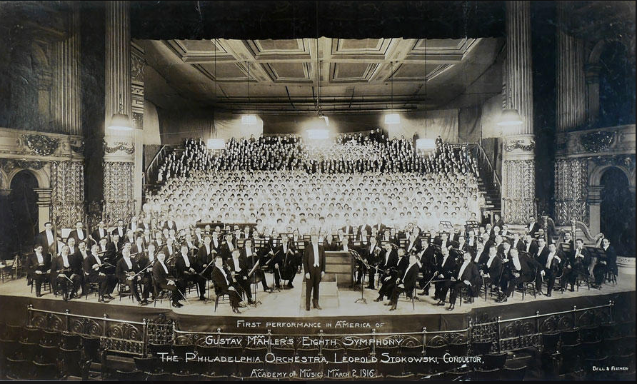 A black and white photo of an orchestra in an auditorium