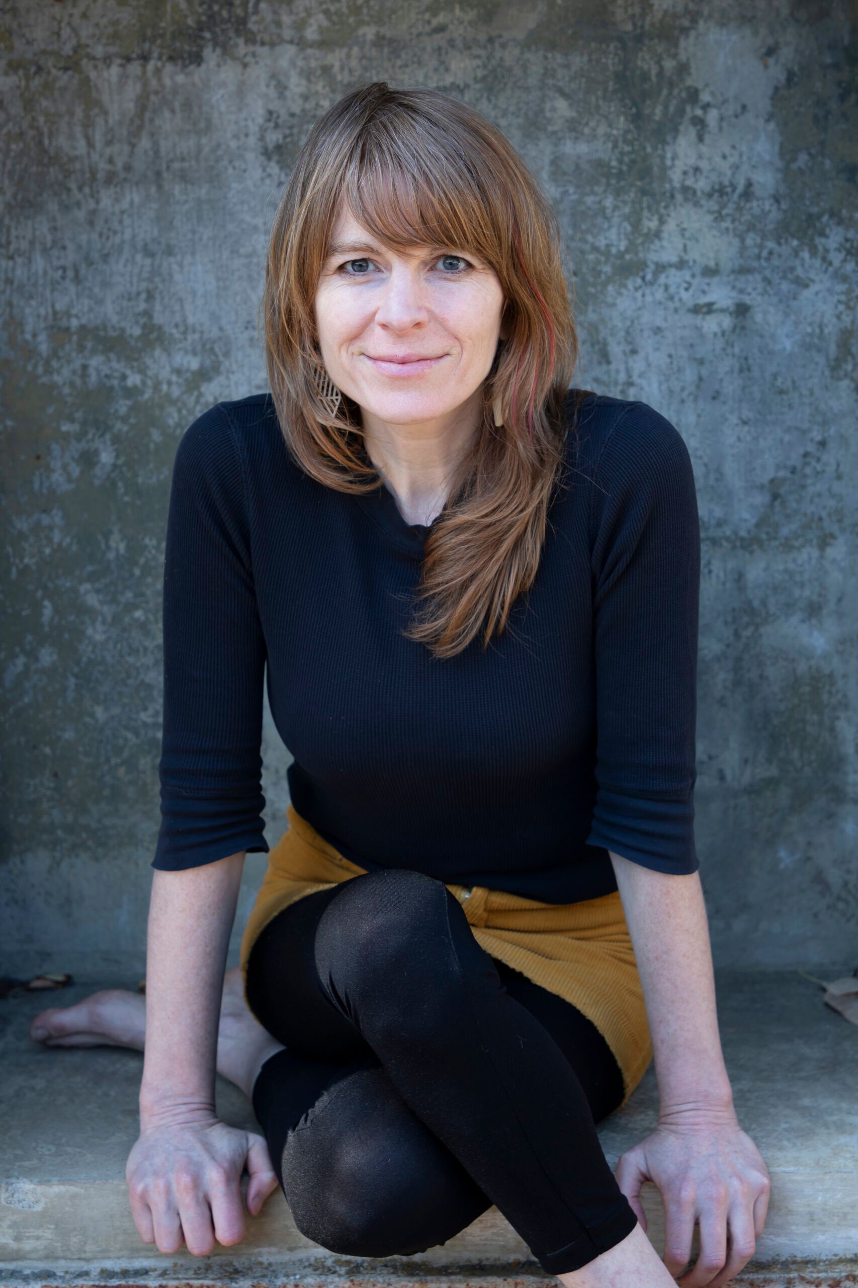 A woman wearing a black dress and a pearl necklace