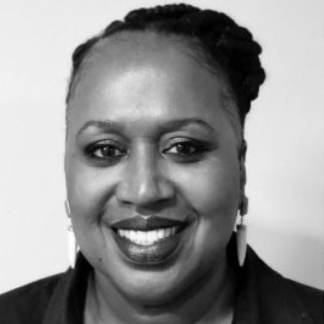 Smiling Black woman with braided hair and dark lipstick, wearing earrings.