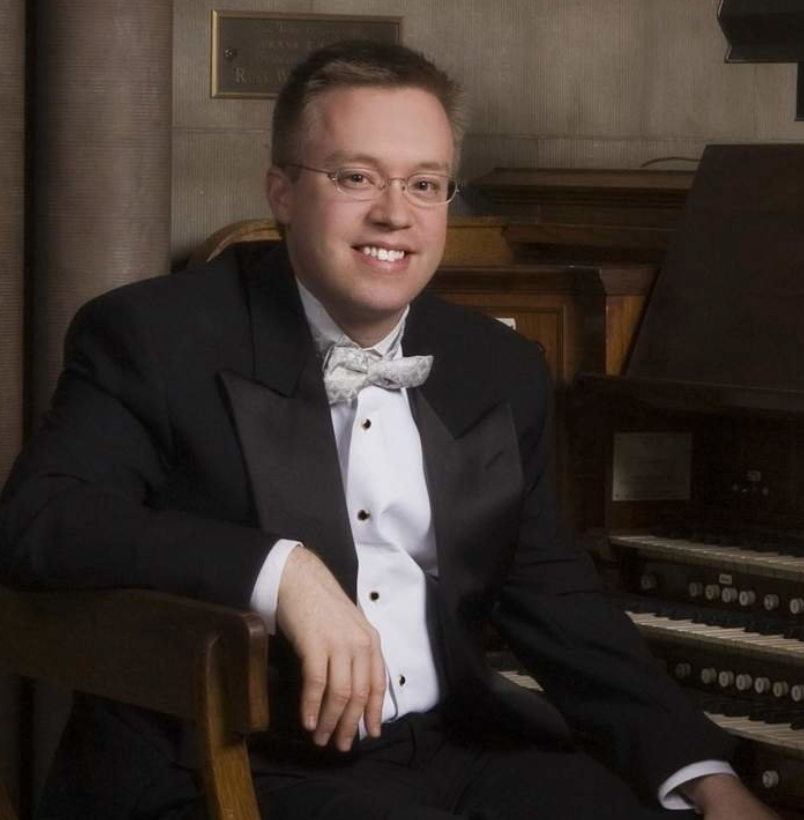 A man in a black shirt is smiling for the camera