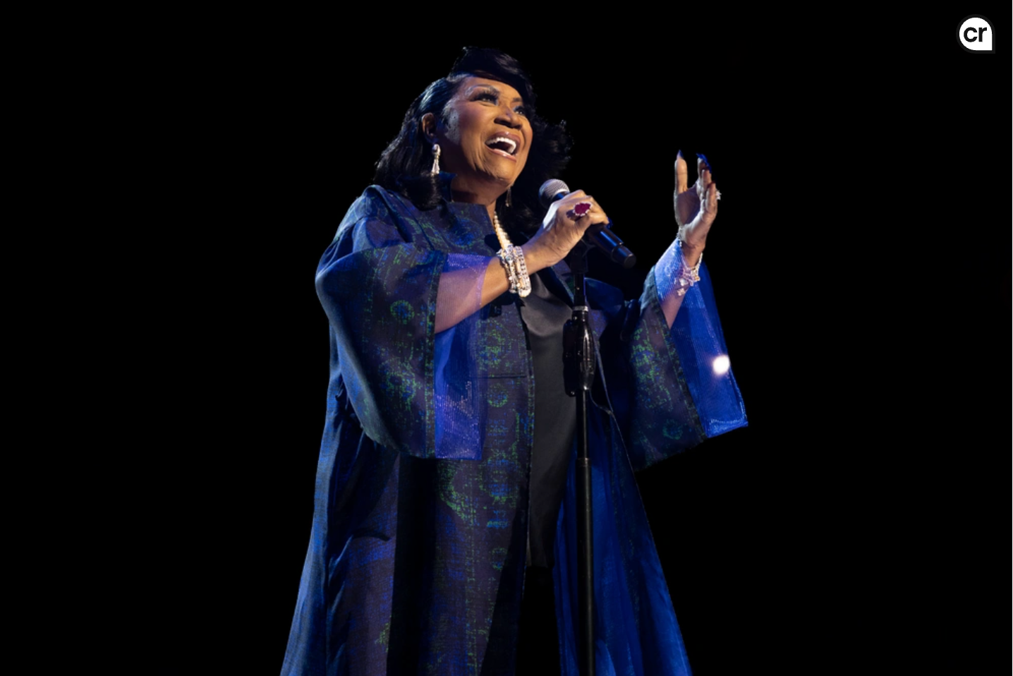 A silver suv is parked in front of a bridge.