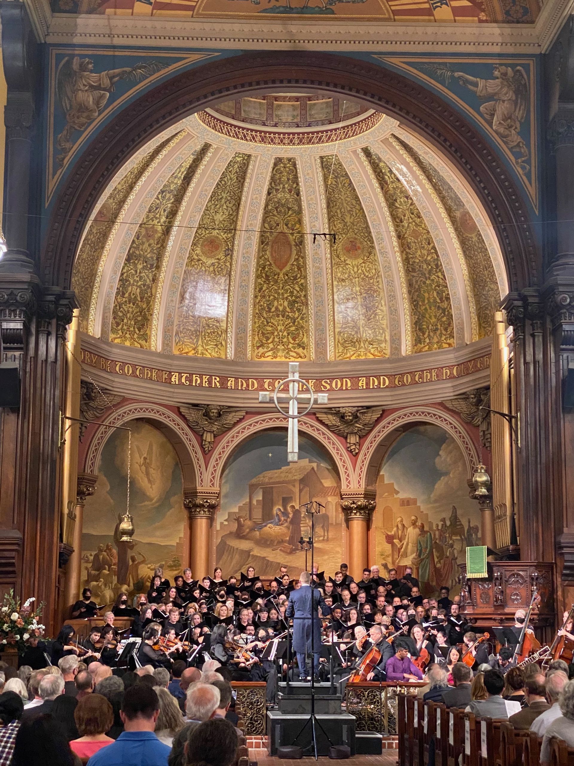 A large group of people are sitting in a church watching a concert