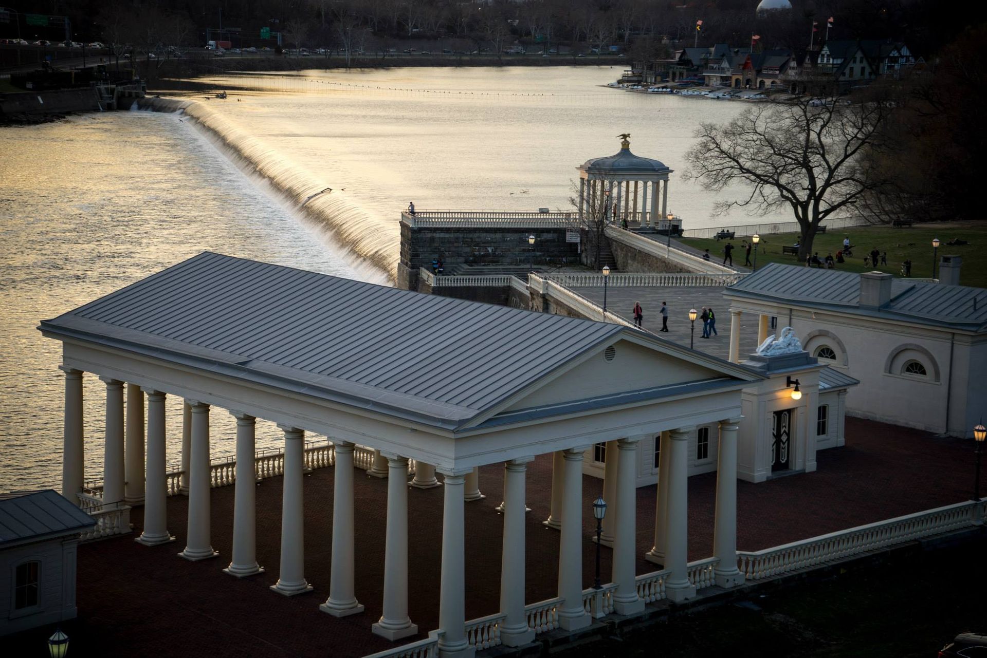 An aerial view of a building with columns overlooking a body of water