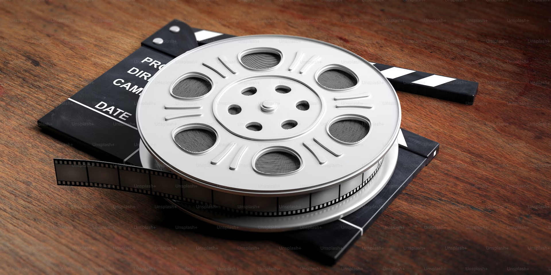 a film reel is sitting on top of a clapper board on a wooden table .