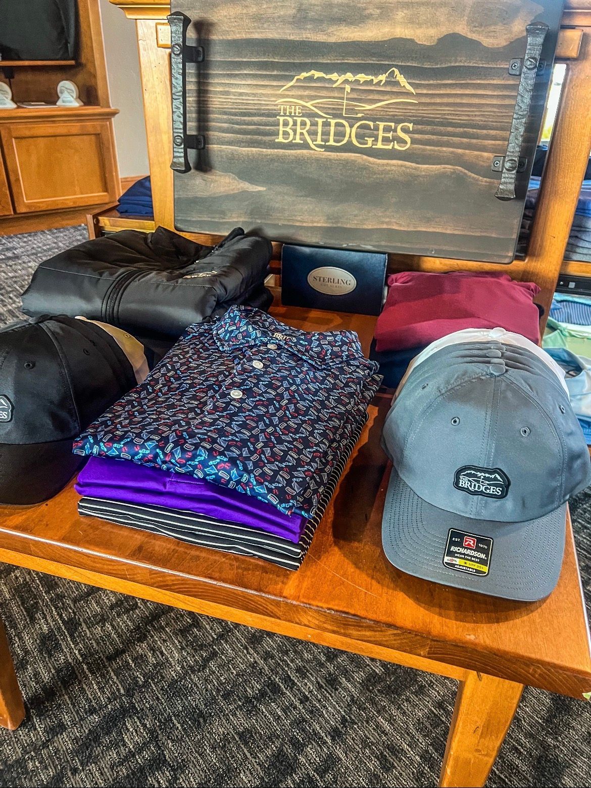 Merchandise display: polo shirts, hats, a tray with