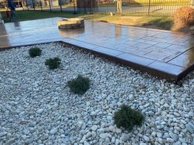 A concrete walkway is surrounded by gravel and plants.