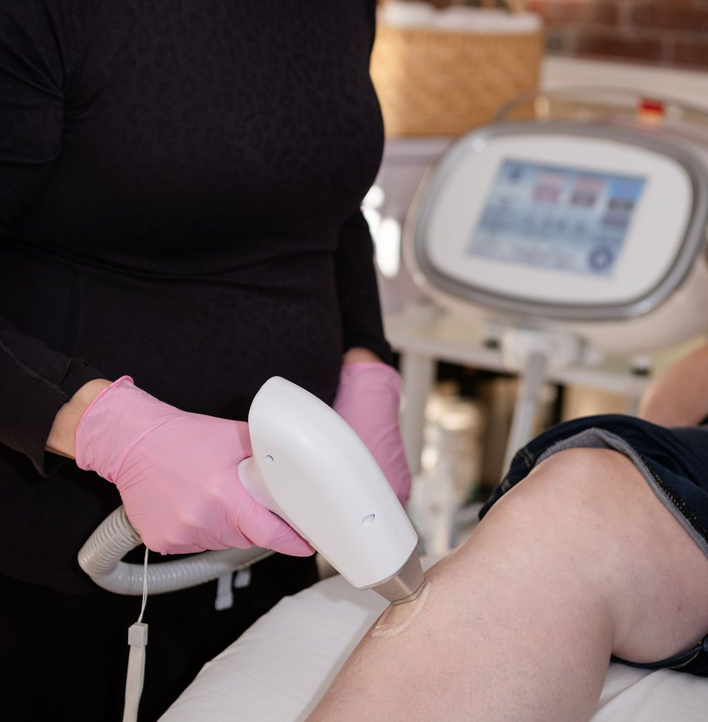 A woman is holding a white feather on her arm.
