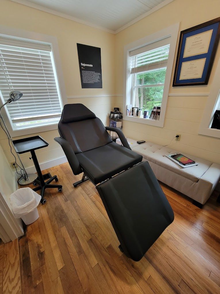 A black chair is sitting in a room next to a window.