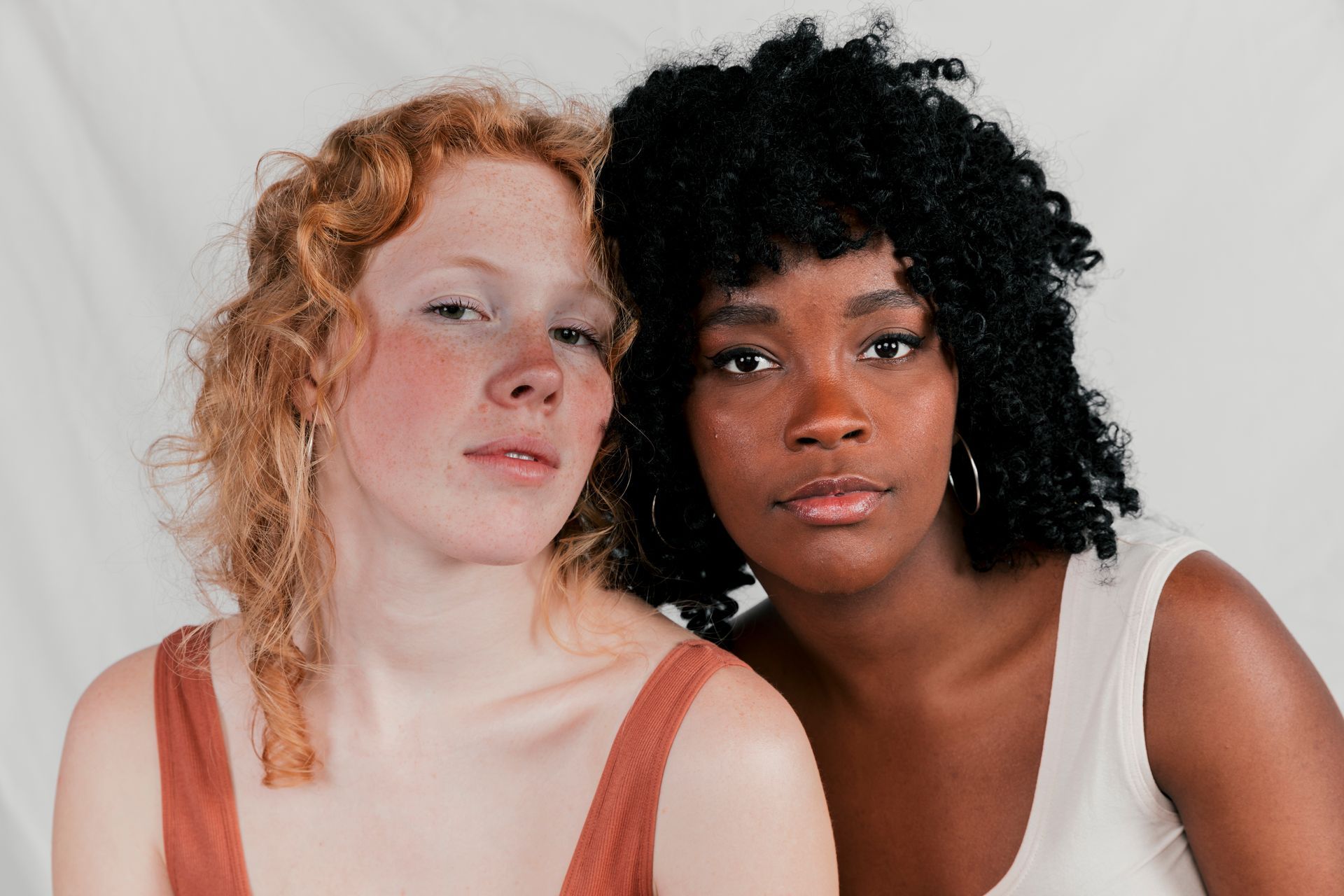 Two women of different races are posing for a picture together.