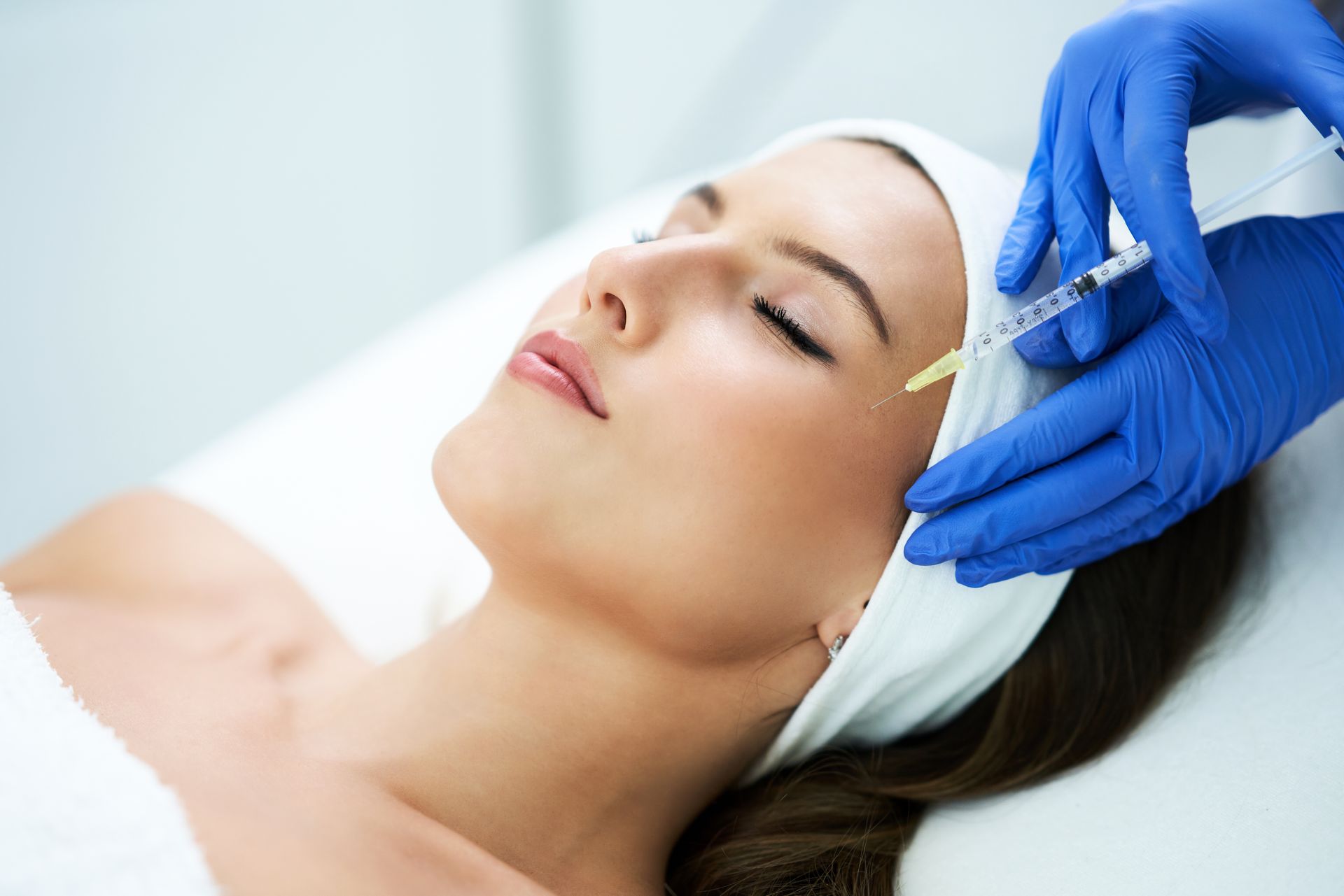 A woman is getting a botox injection in her face.