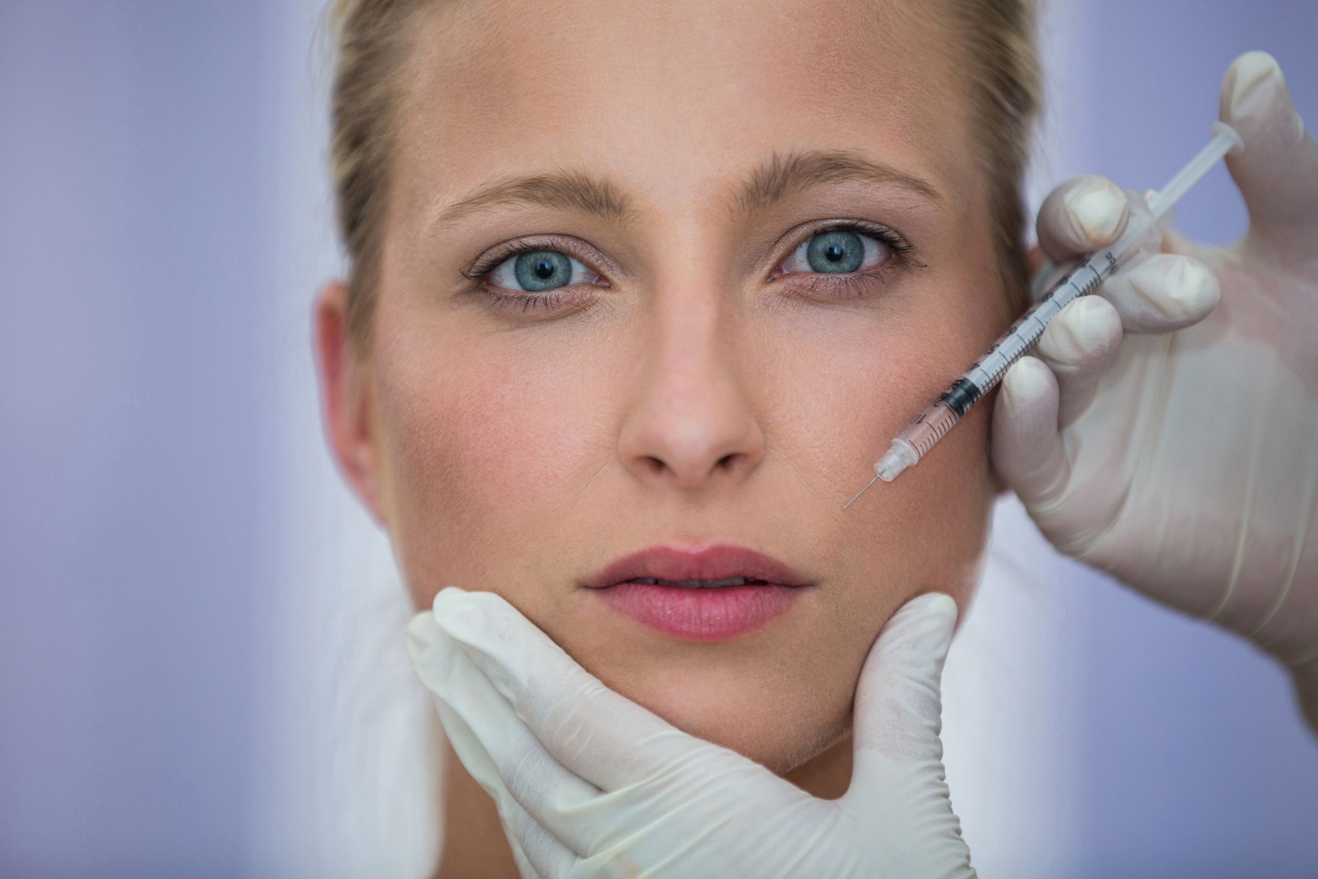 A woman is getting a botox injection in her face.