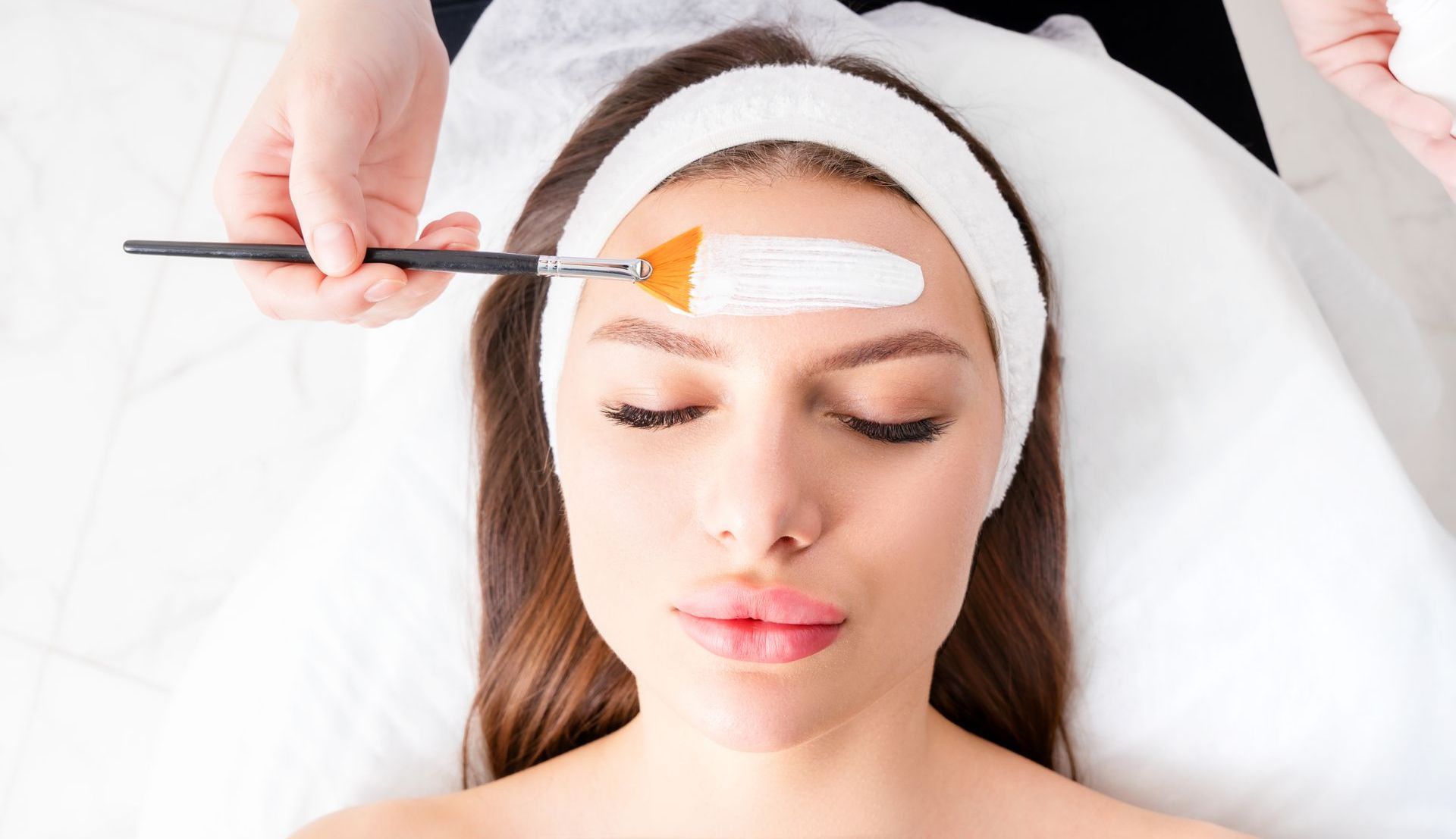 A woman is getting a facial treatment at a spa.