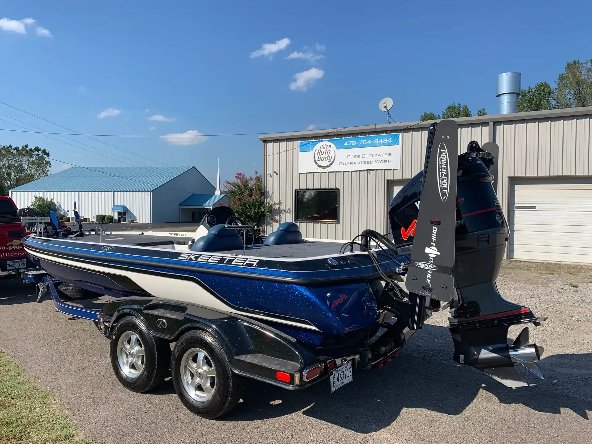 What To Expect Keeping It Crappie Guide Service Fishing Charter in Lake Dardanelle Arkansas A blue fishing boat on a trailer is parked in front of a building.