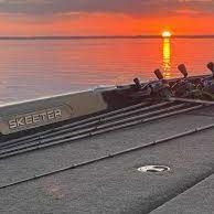 A 21 Skeeter bass boat with fishing rods on the deck at sunset. Sponsor Keeping It Crappie Guide Service Fishing Charter in Lake Dardanelle Arkansas
