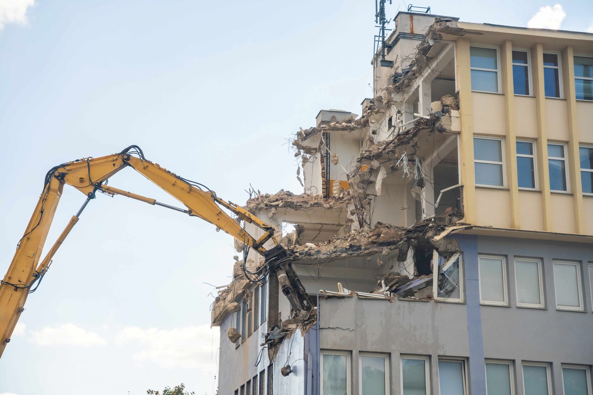 Excavator demolishing a multi-story building during a professional structure demolition project.