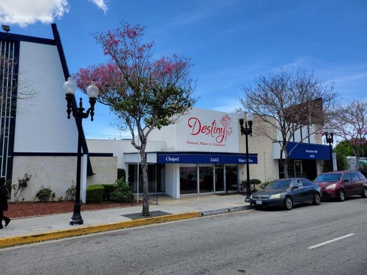 A family is walking on the beach holding hands.