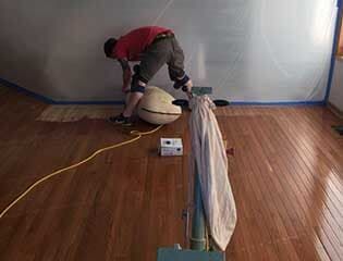 Man Installing Hardwood Floor — Puyallup, WA — Blair & Son Floor Co.