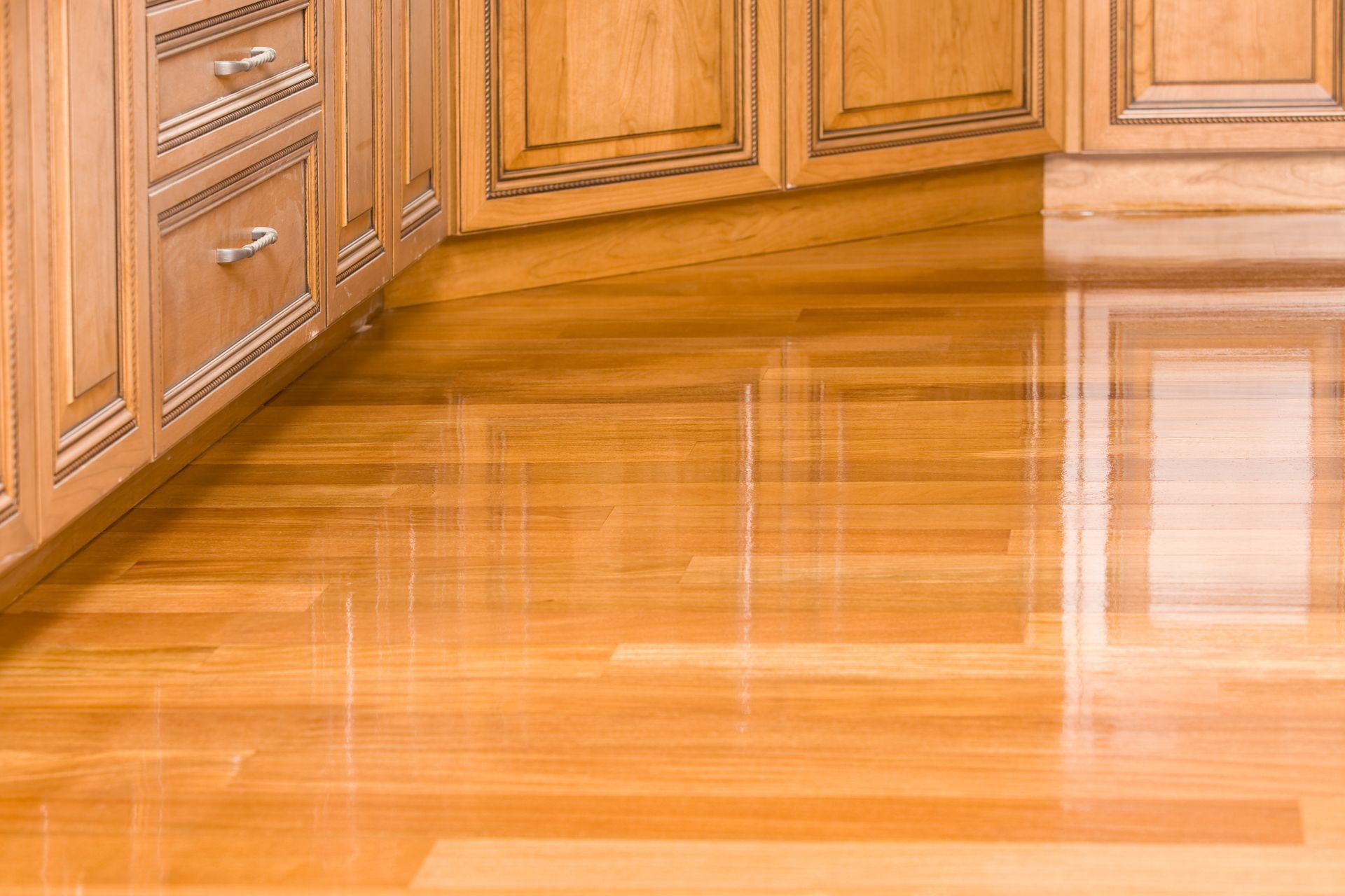 Close-up of a freshly stained kitchen hardwood floor, showcasing expert hardwood floor refinishing.