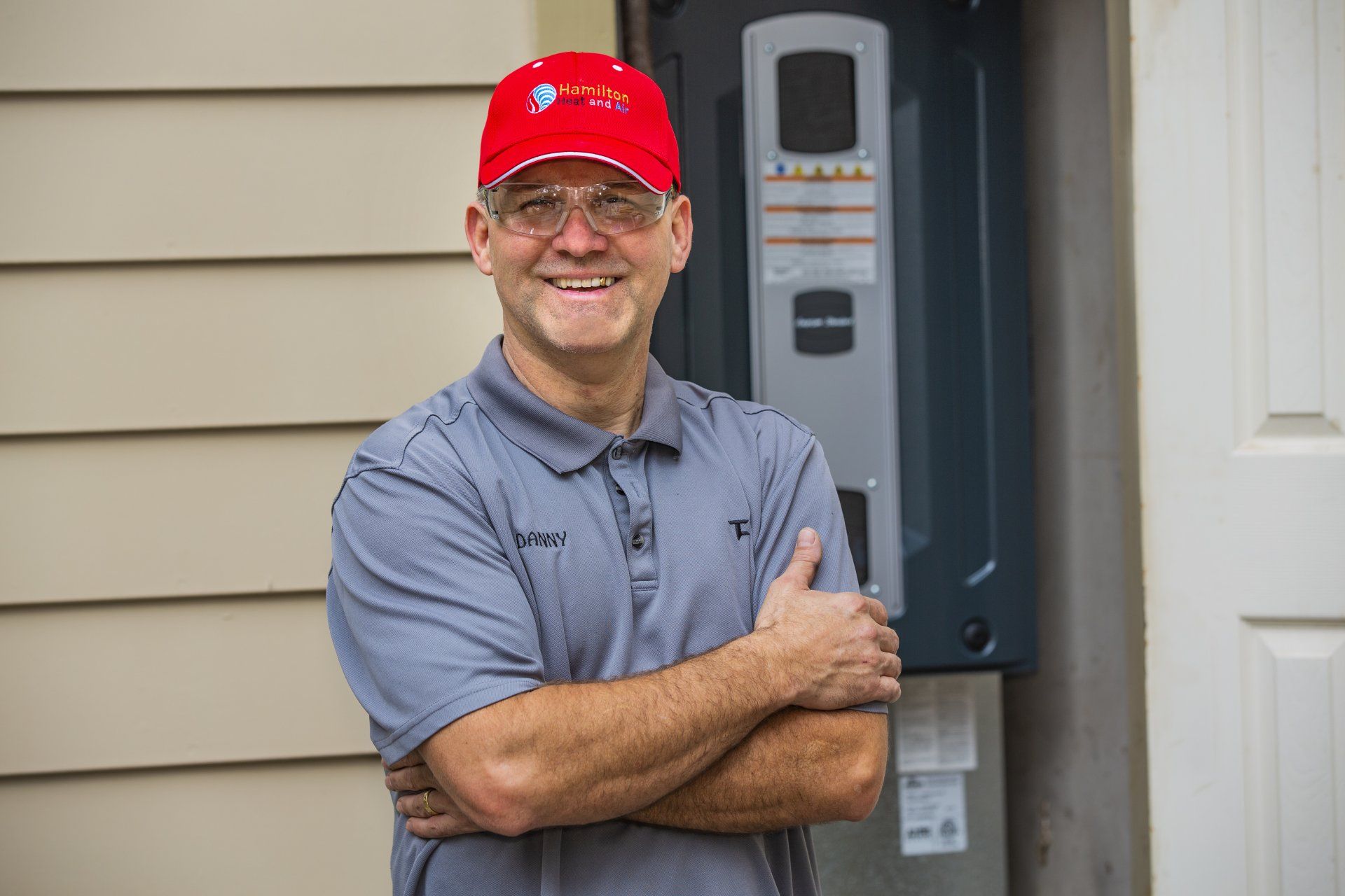 man posing by wall with arms crossed