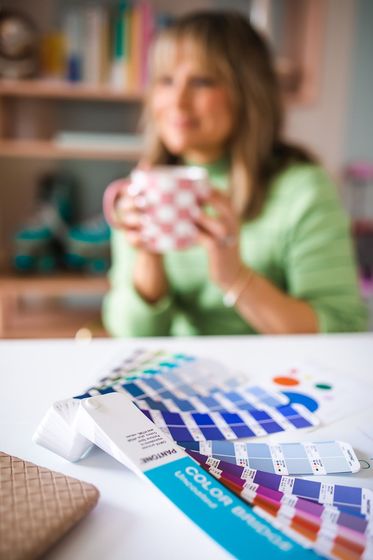 A woman is sitting at a table holding a cup of coffee.