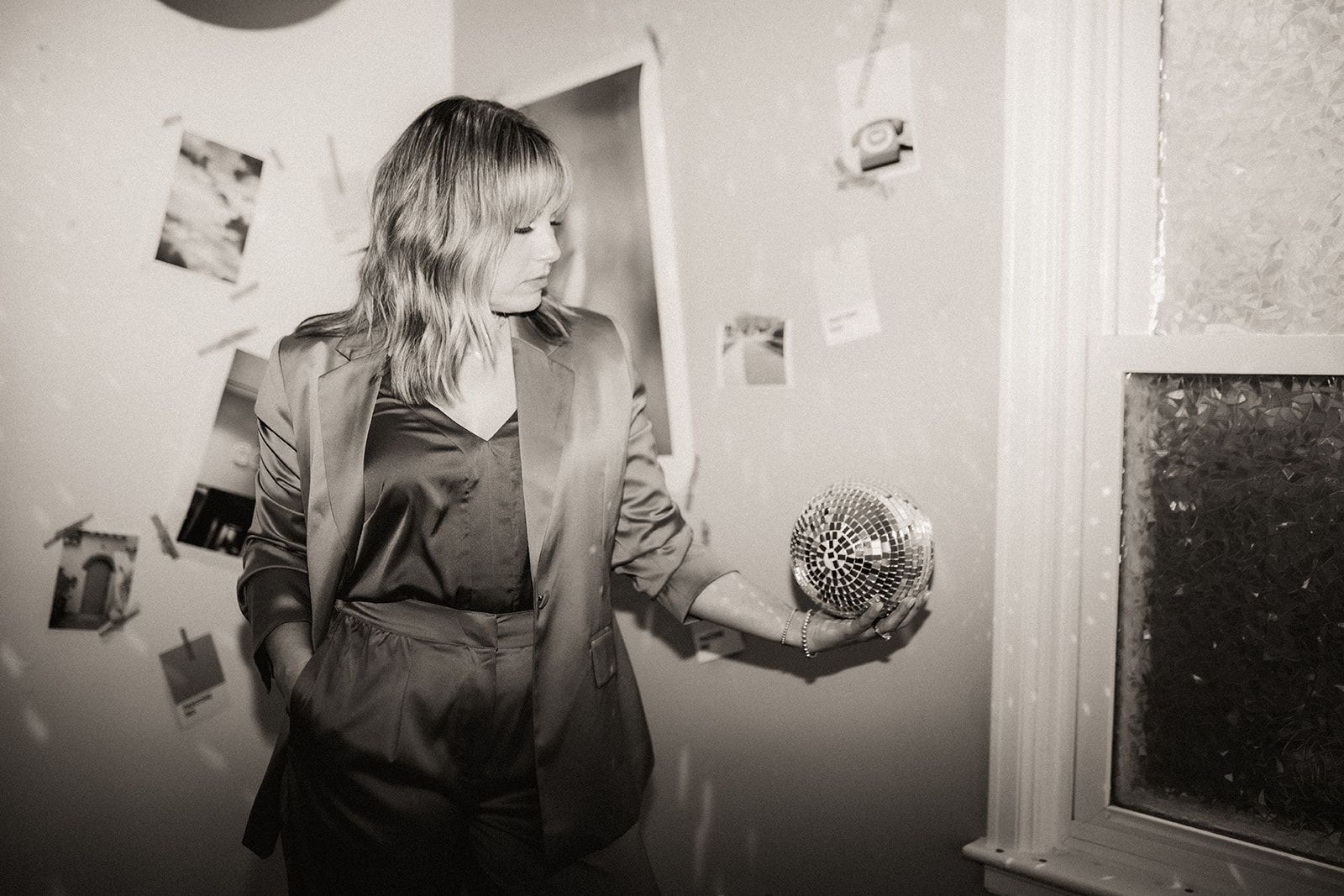 A woman is standing in a room holding a ball in her hands.