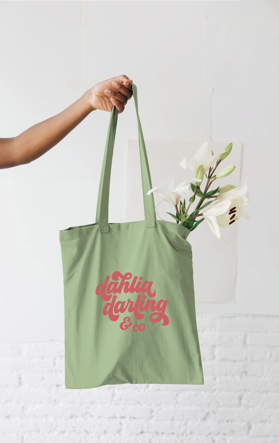 A person is holding a tote bag with flowers in it.