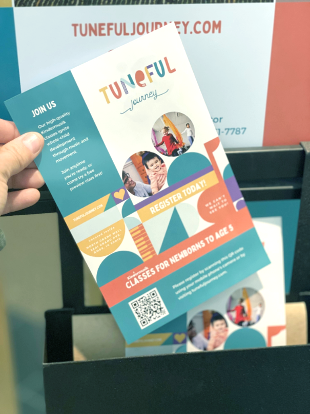 A person is holding a flyer for tuneful journey