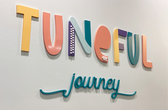 A sign on a wall that says tuneful journey