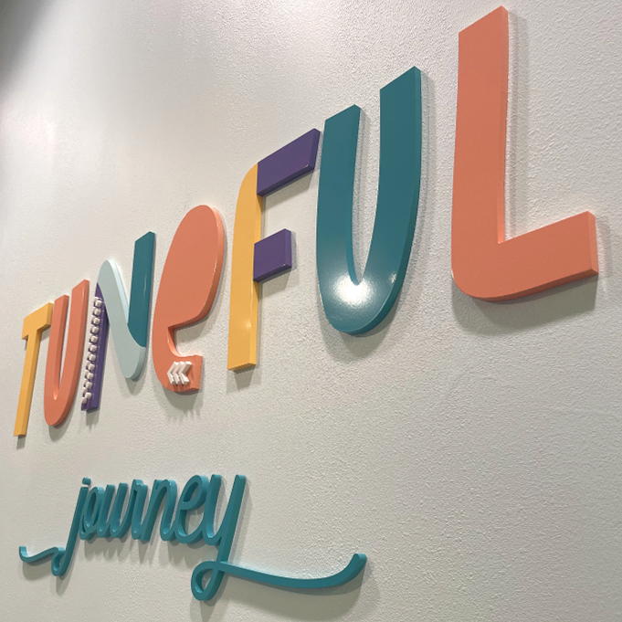 A sign on a wall that says tuneful journey