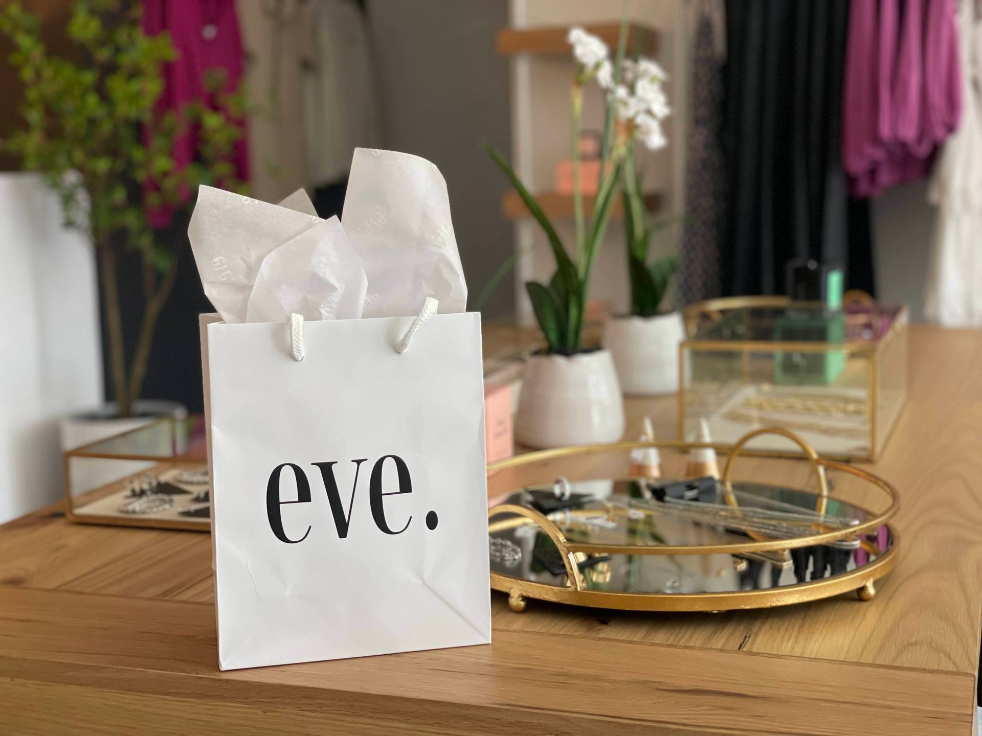 A white bag with the word eve on it is sitting on a wooden table.