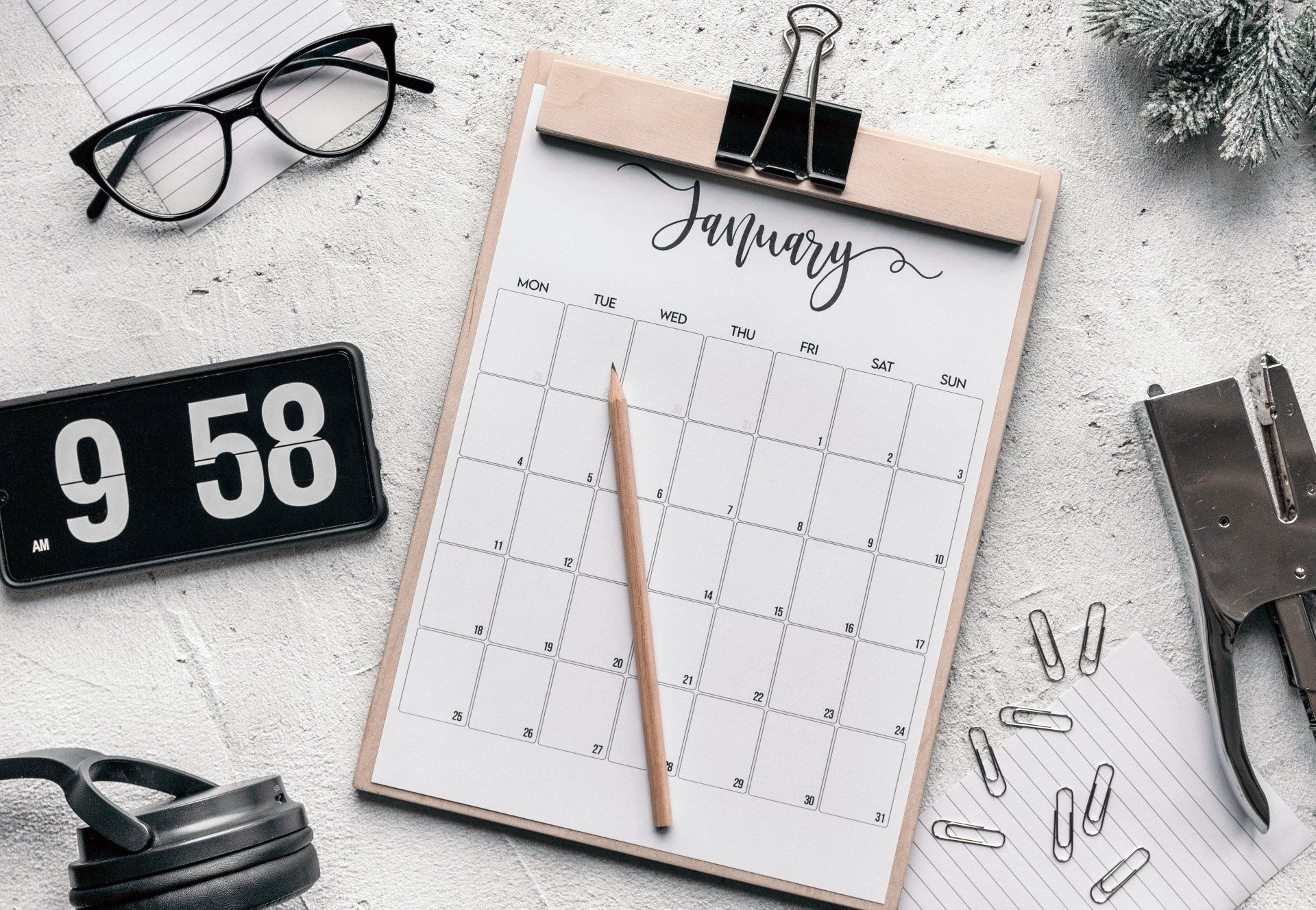 A clipboard with a calendar and a pencil on it.