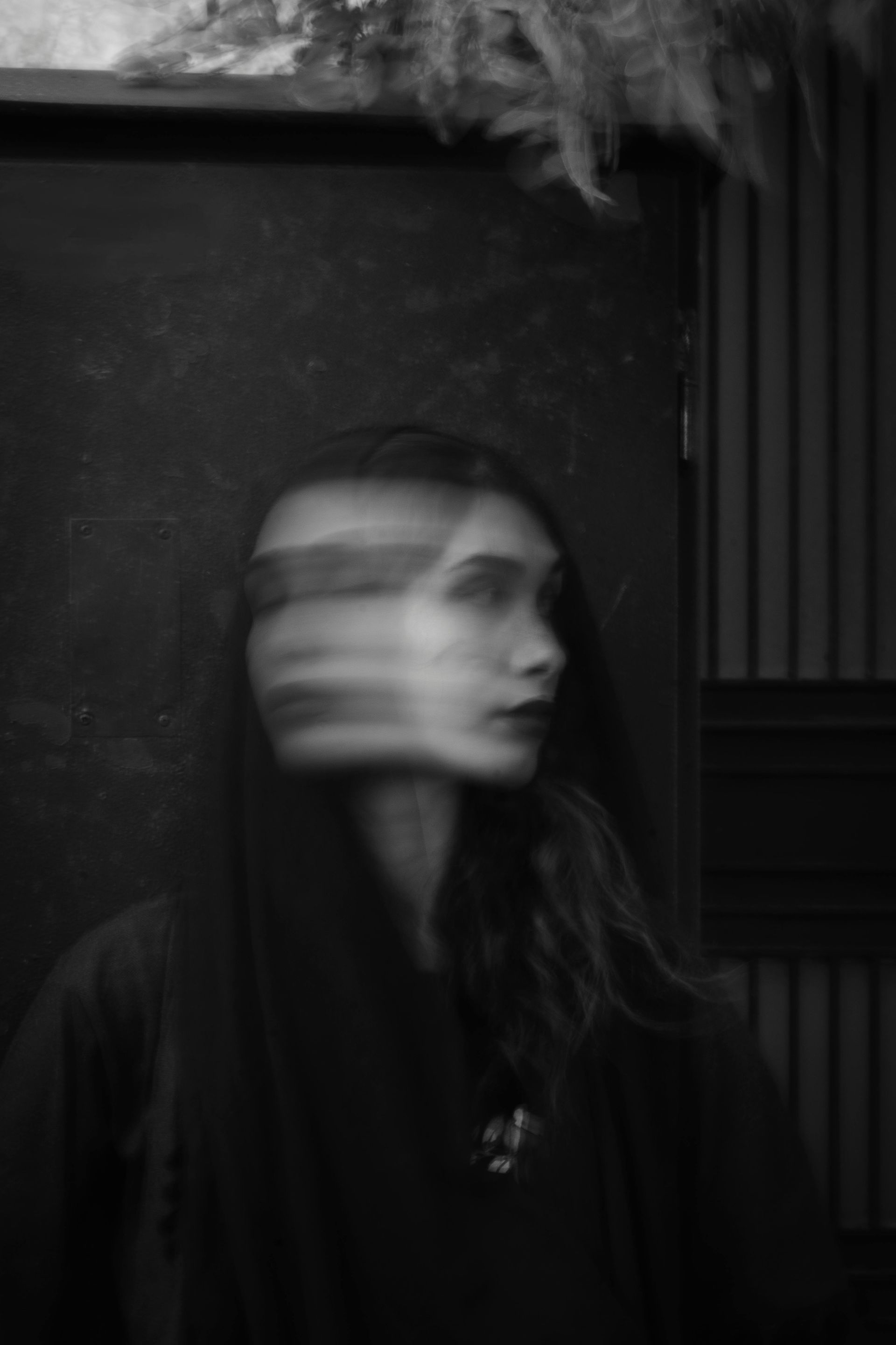 A blurry black and white photo of a woman 's face.