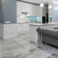 Modern white and gray kitchen with marble floors and a tufted gray sofa island