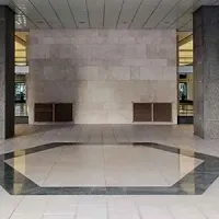 Empty modern lobby with a marble wall, tiled floor, and geometric floor pattern
