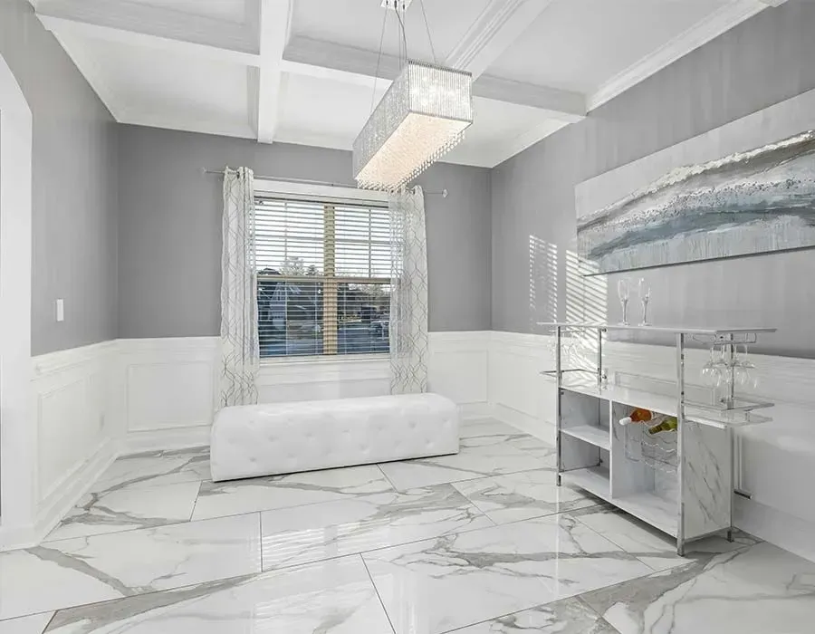 Bright modern bathroom with marble floor, white bench, window blinds, and glass vanity.