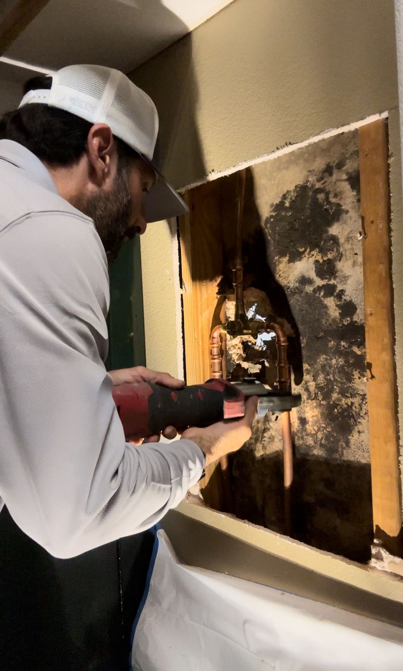 A man is working on a wall with a tool.
