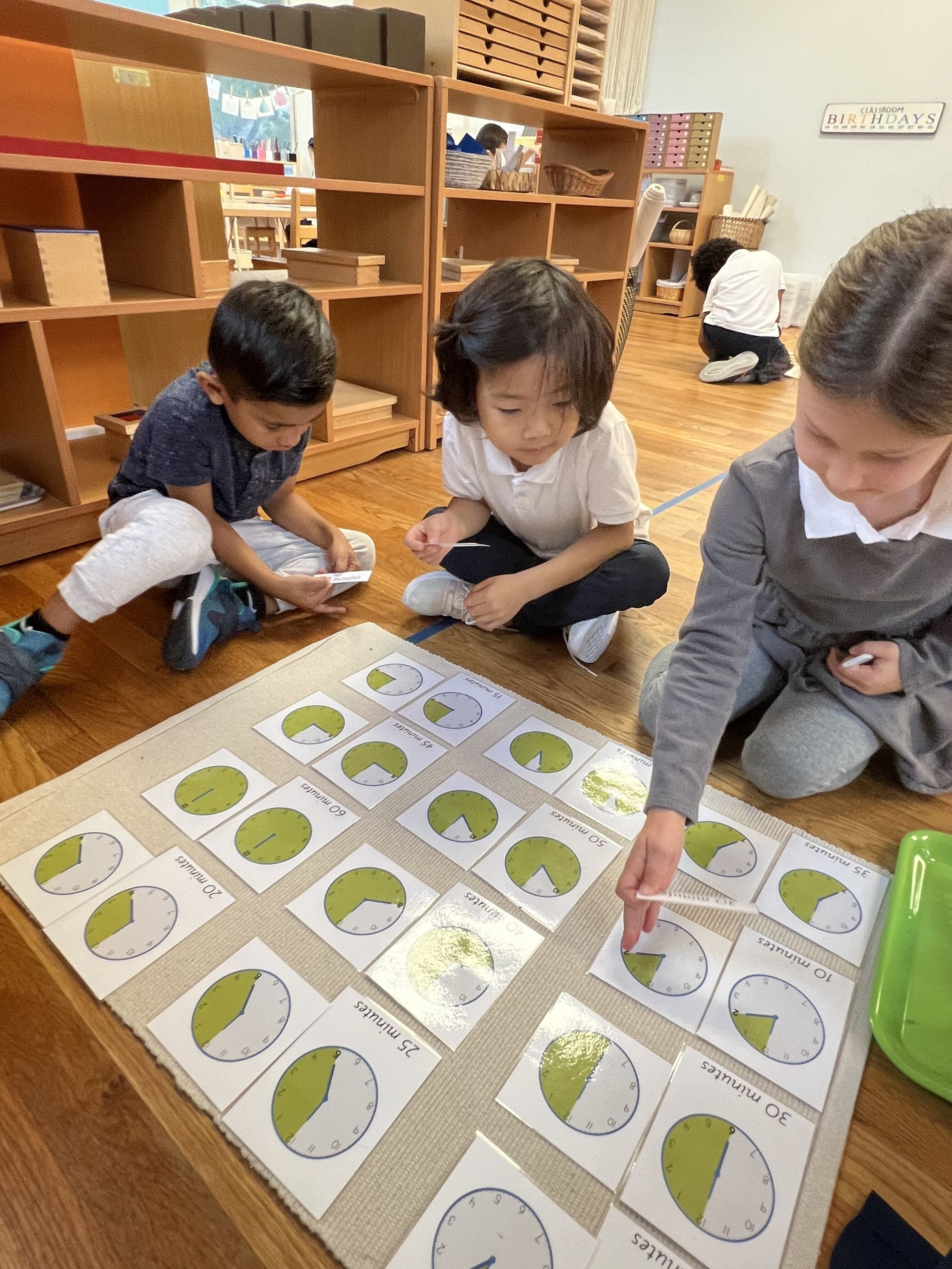 A group of Montessori child working wirth math materials