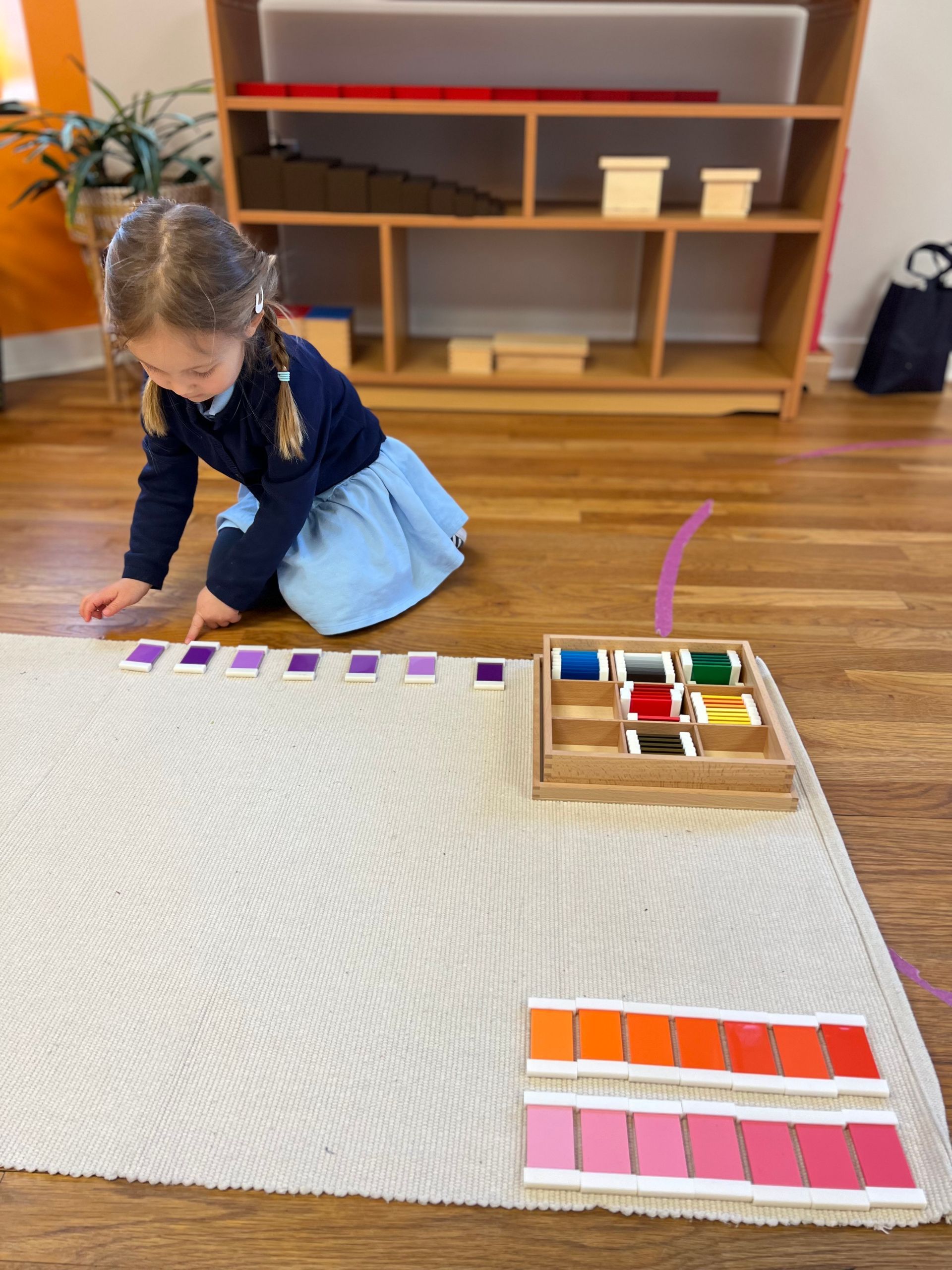 Montessori child is working with Montessori outlet color tablets in the classroom