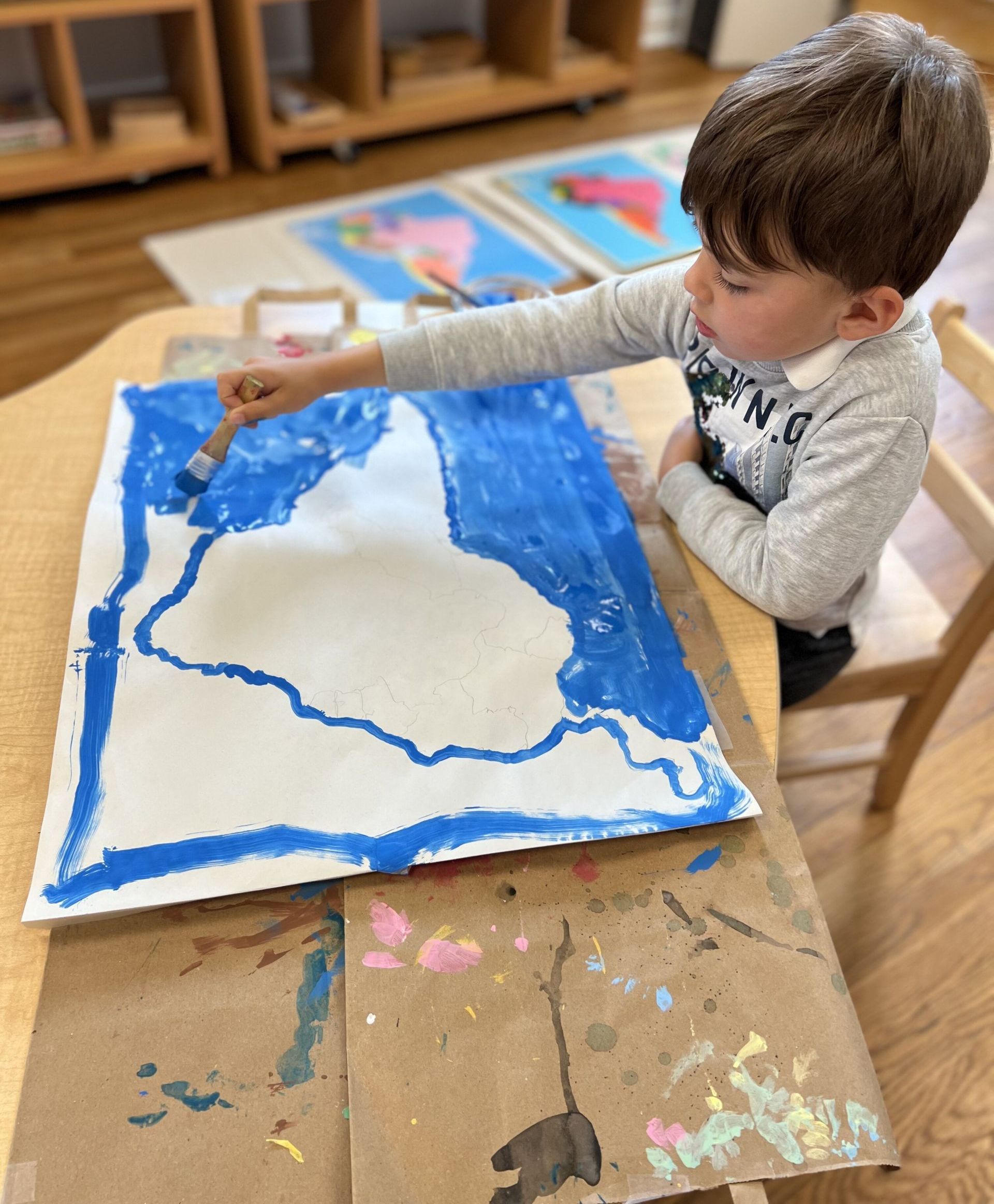 Motessori child is painting in the classroom