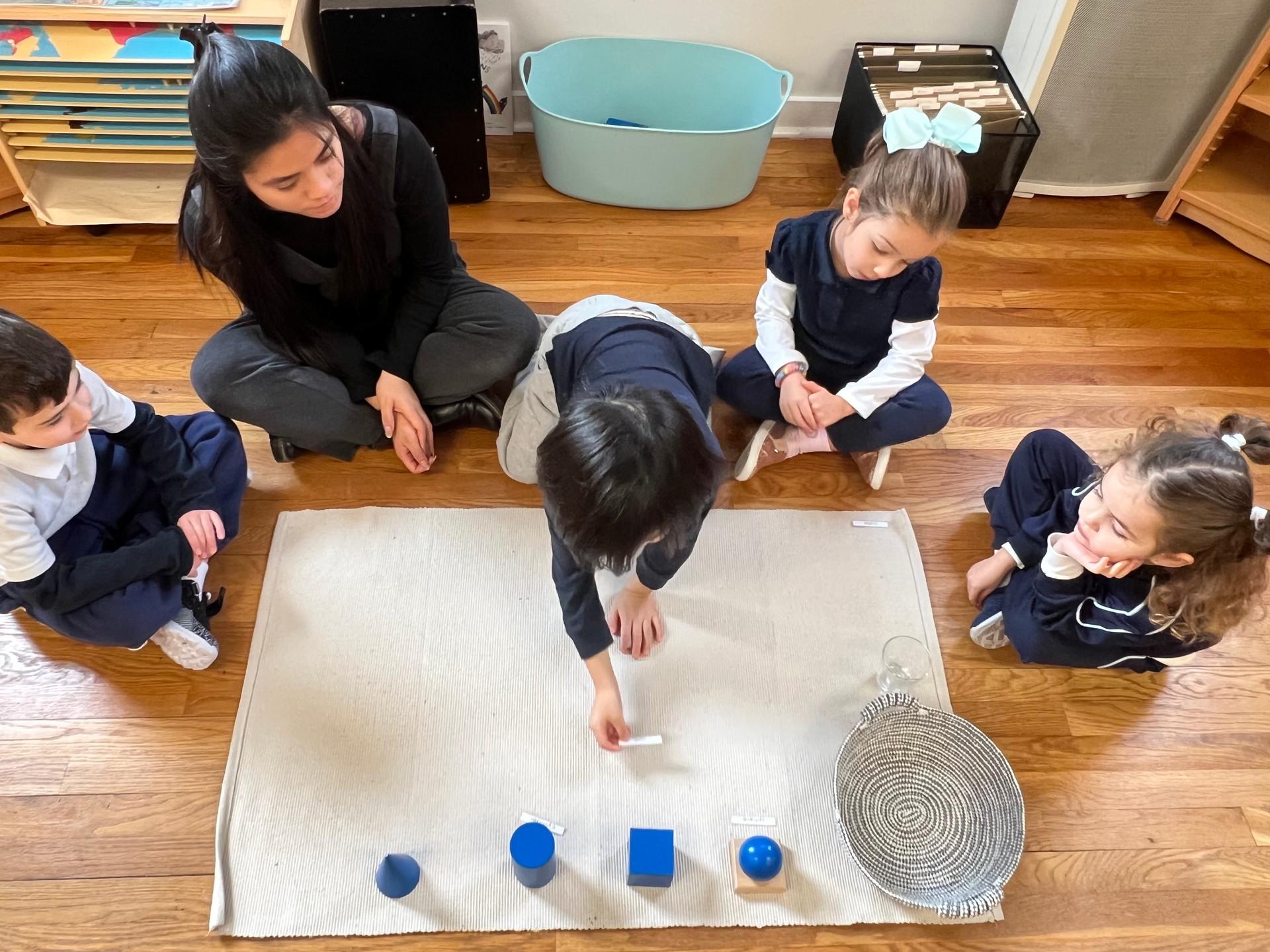 Montessori guide and-children in classroom