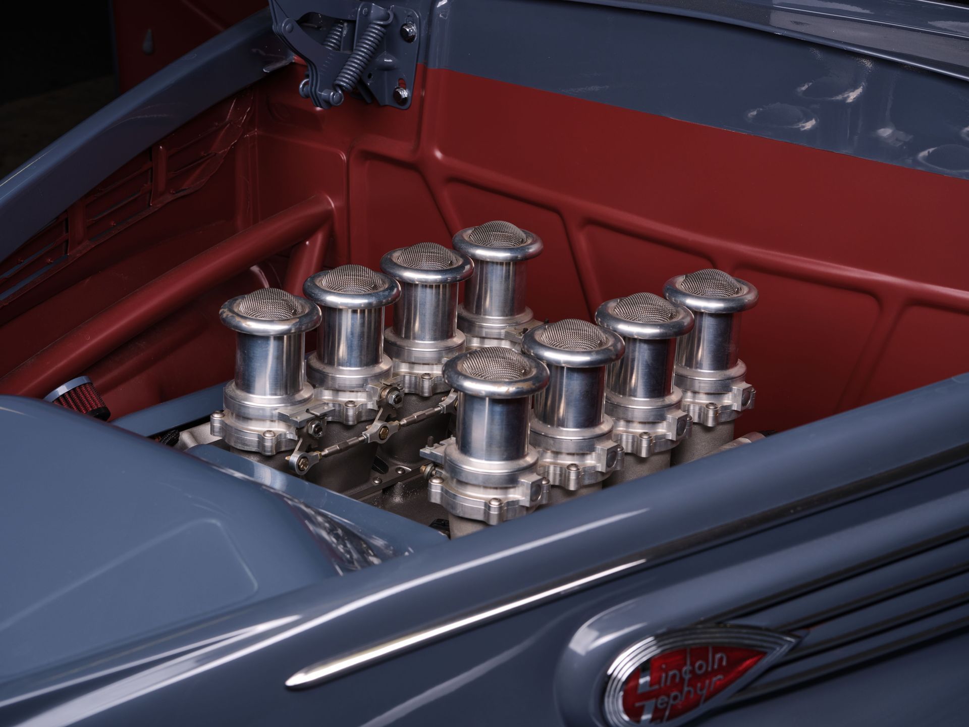 Chrome engine in a blue car with red interior compartment