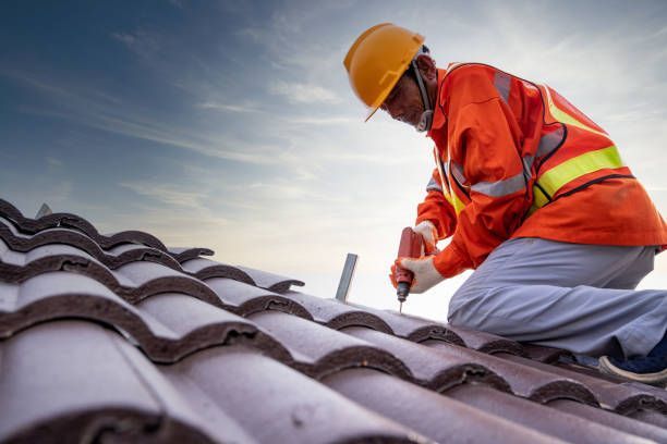 Worker with helmet using drill to install roof, highlighting commercial roofing contractor services.