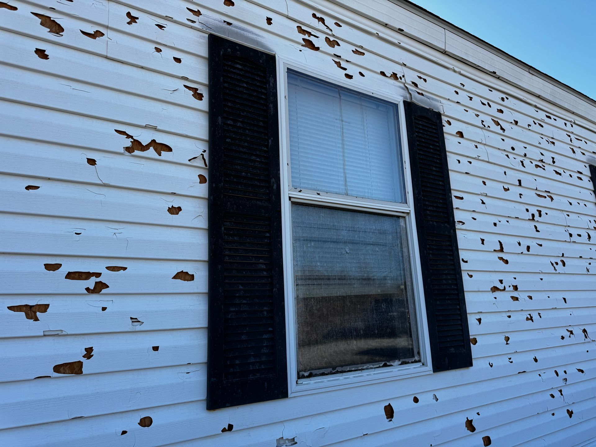 A white house with black shutters and a window