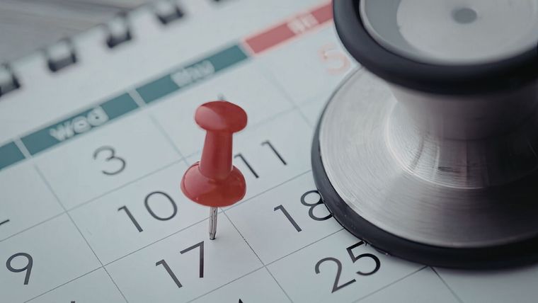 A stethoscope rests on a calendar next to a red pushpin marking the 17th.