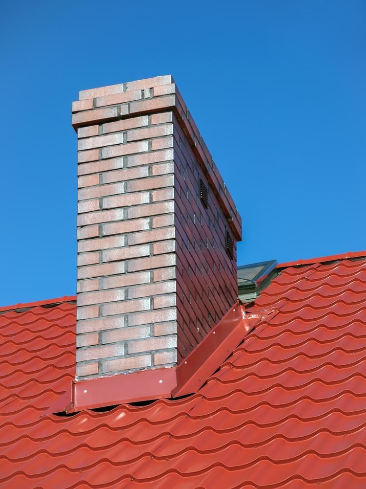 A Brick Chimney on Top of A Red Tiled Roof — Bradley Roofing in Tuncurry, NSW