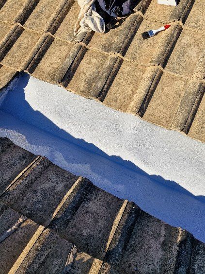 A Man Is Working on A Roof — Bradley Roofing in Tuncurry, NSW