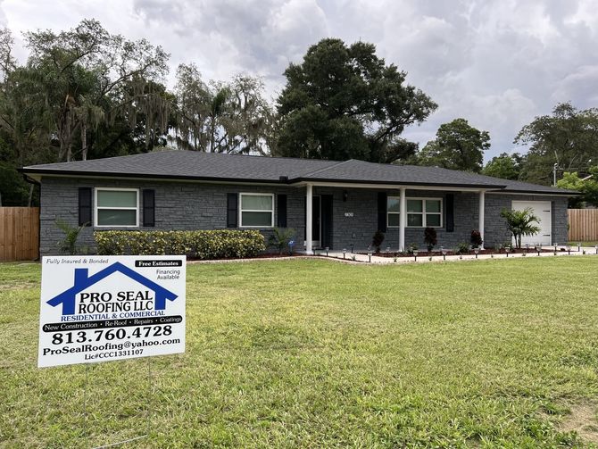 A house with a sign in front of it that says precision roofing