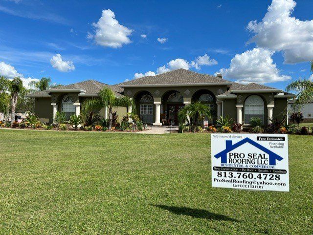 A large house with a pro seal roofing sign in front of it