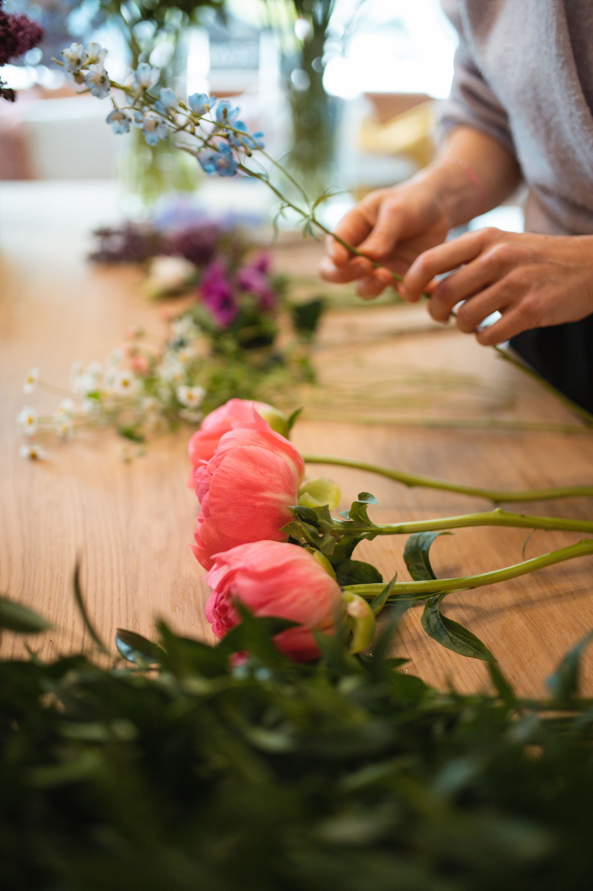 A woman is arranging flowers on a table.
